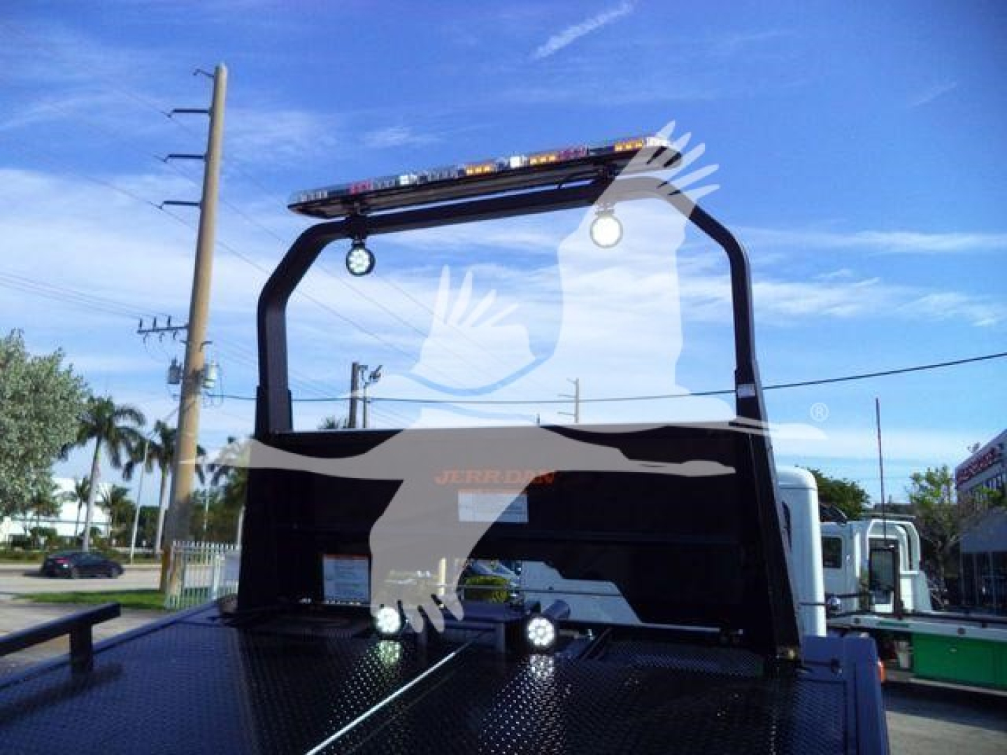 Peterbilt 536 rollback truck rear view showing overhead engine hoist and platform with lighting bar and brand decals.