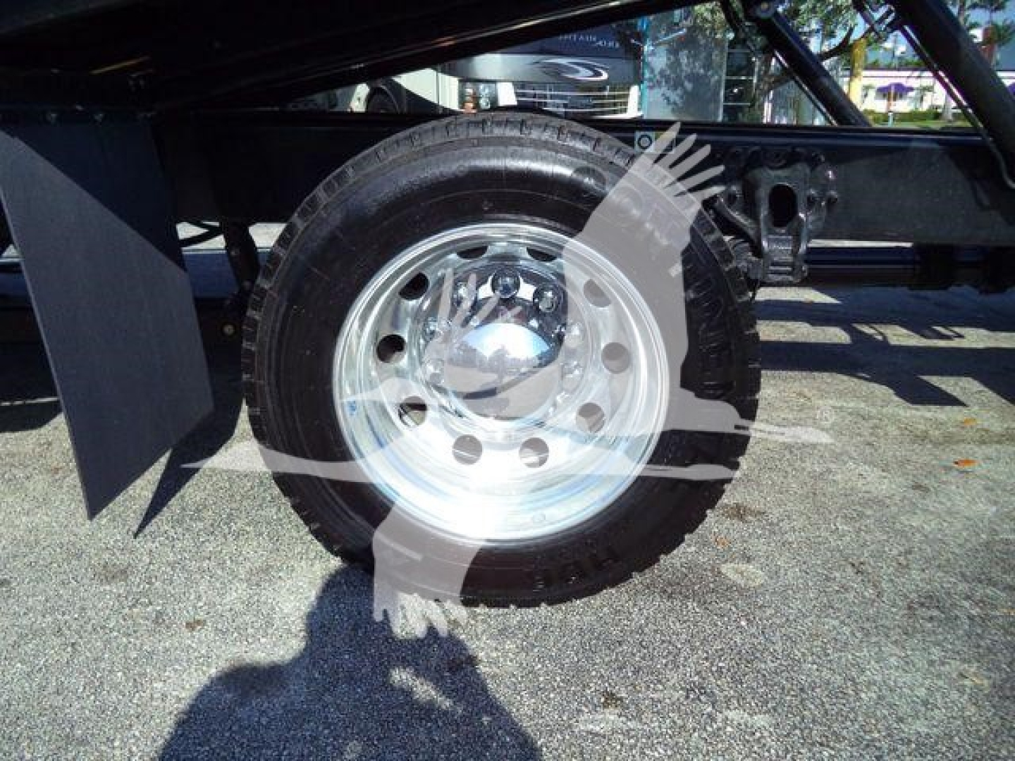 Peterbilt 536 rollout truck wheel and tire assembly visible under frame with chrome hub and black tire.