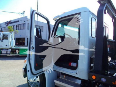 Peterbilt truck cab interior with open door, side step, and emergency fire extinguisher visible inside cab.