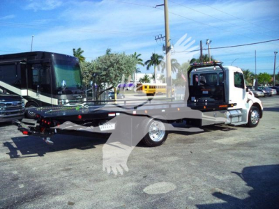 Peterbilt 536 rollback tow truck with flatbed and cab in view.