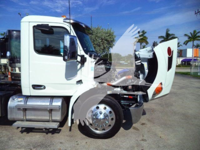 Truck cab with hood open showing engine bay area and front wheel; Peterbilt 536 rollback truck in white