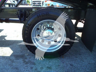Peterbilt 536 rollback truck wheel and tire with chrome hub, undercarriage framing visible.