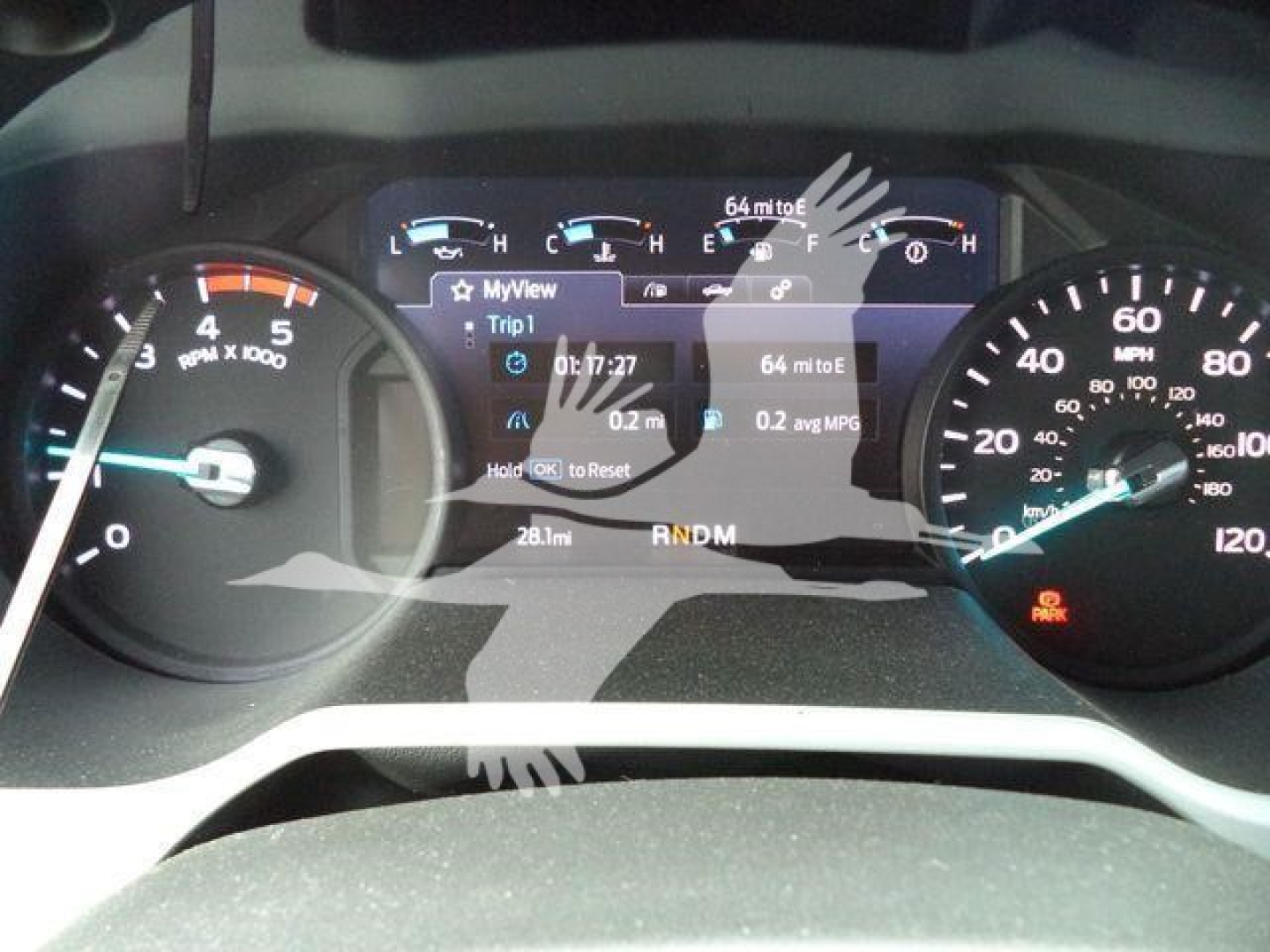 Dashboard showing speedometer and tachometer with a central digital display reading MyView Trip1, 0.7?7:27, 0.2 avg MPG, 64 mile to E, and PRNDM gears