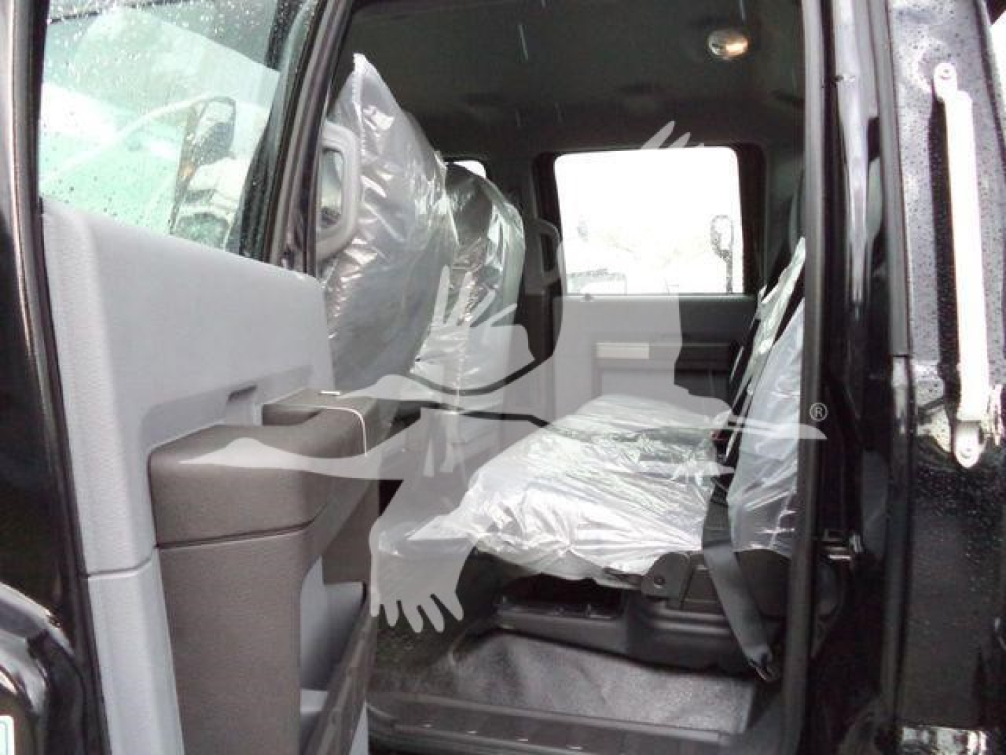 Ford F-750 SD rollback truck interior showing front passenger seat and doorway with plastic-covered seats.