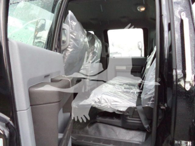Ford F-750 SD rollback truck interior showing front passenger seat and doorway with plastic-covered seats.