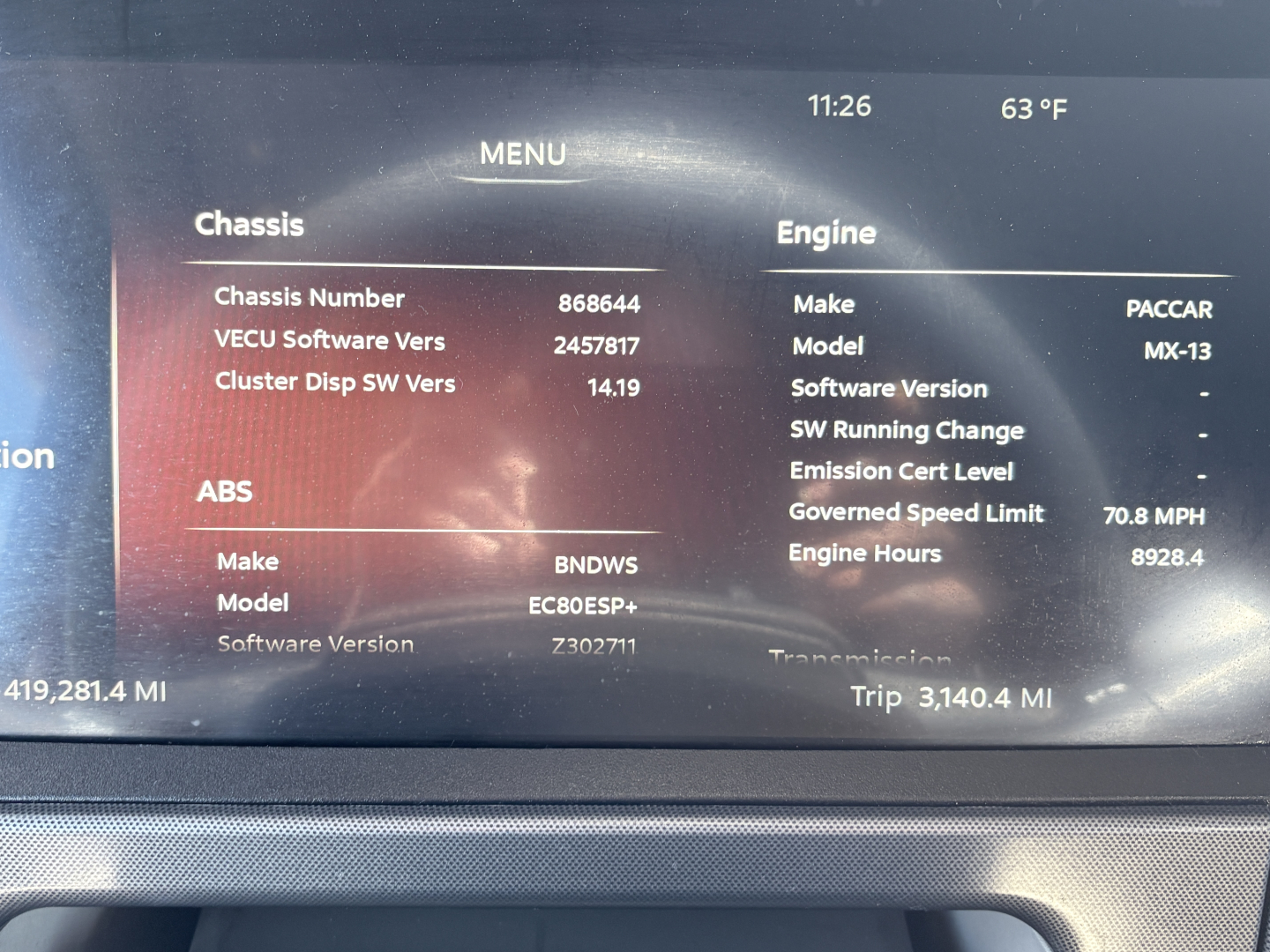 Truck dash display showing Menu with Chassis and Engine sections. Text includes Chassis Number 868644, VECU Software Vers 2457817, Cluster Disp SW Vers 14.19, ABS Make BNDWS Model EC80E3P+, Software Version 72302771, Make PACCAR Model MX-13