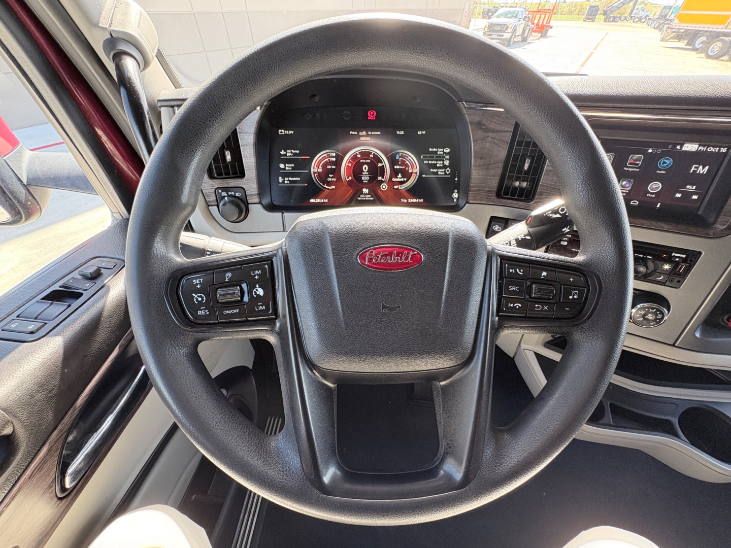 Peterbilt 579 steering wheel and dashboard interior showing digital gauges and controls in the cab.