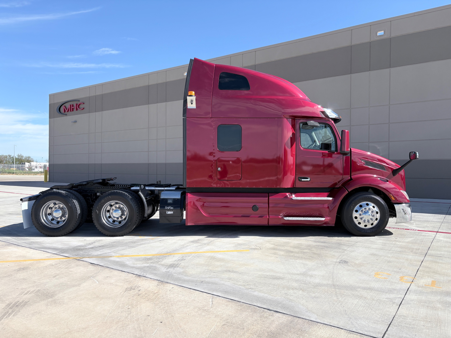 Peterbilt 579 semi-truck in maroon color, side view showing sleeper cab and dual rear axle configuration.