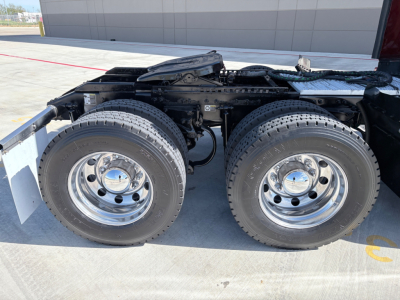 Peterbilt 579 chassis with dual rear axles and polished aluminum wheels showing tires and suspension components.