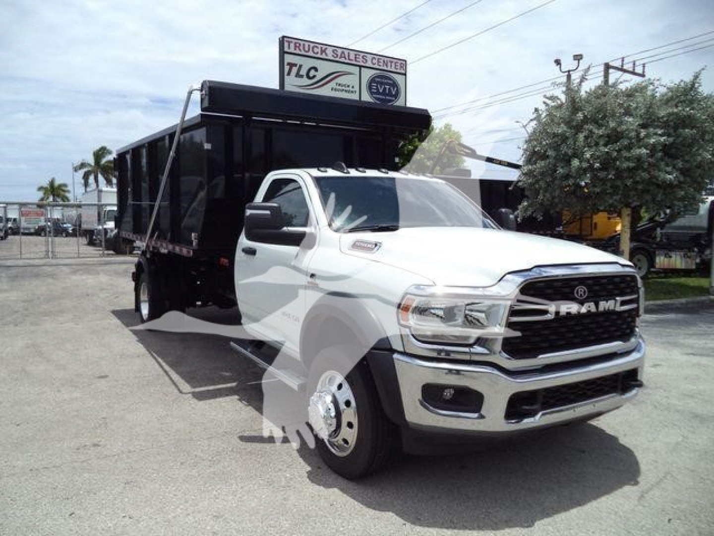Ram 5500 SLT front-side view with a dump bed/rolloff container attached to the truck chassis.