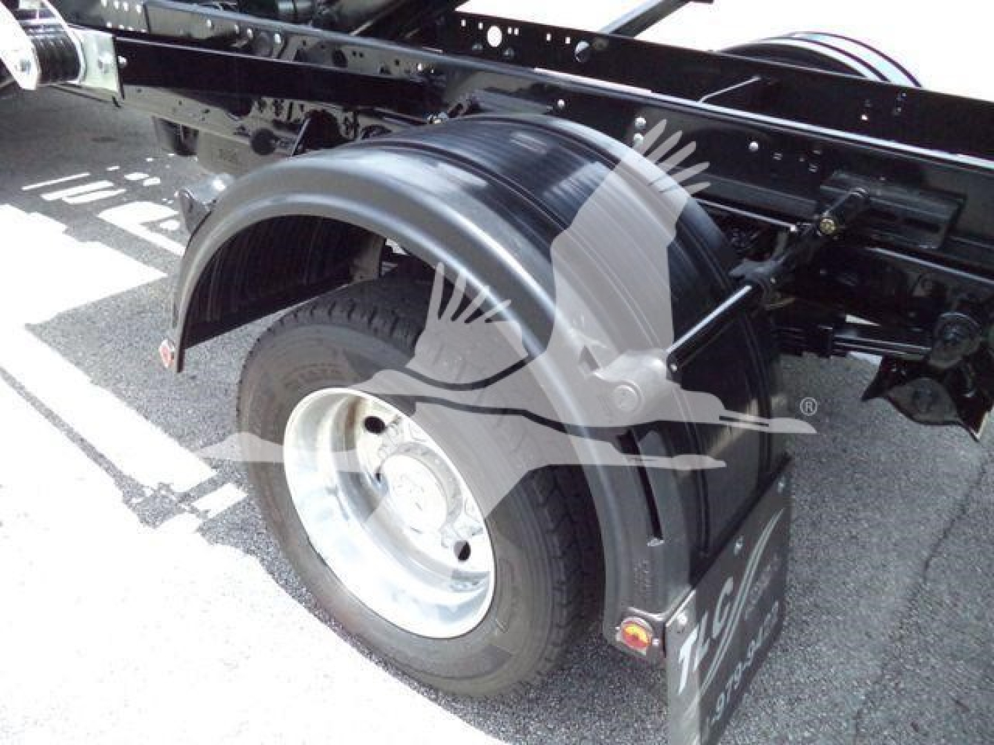 Ram 5500 roll-off truck wheel area showing front wheel and fender with frame rails and mudguard.