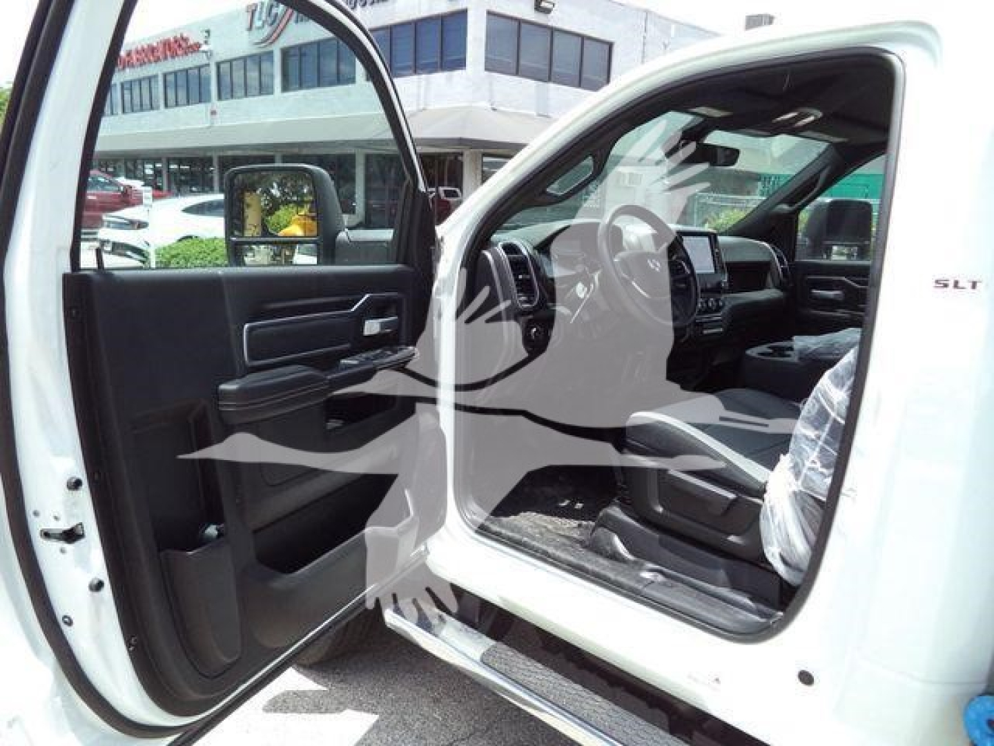 Ram 5500 SLT truck cab interior and open front door showing steering wheel and dashboard labeled SLT