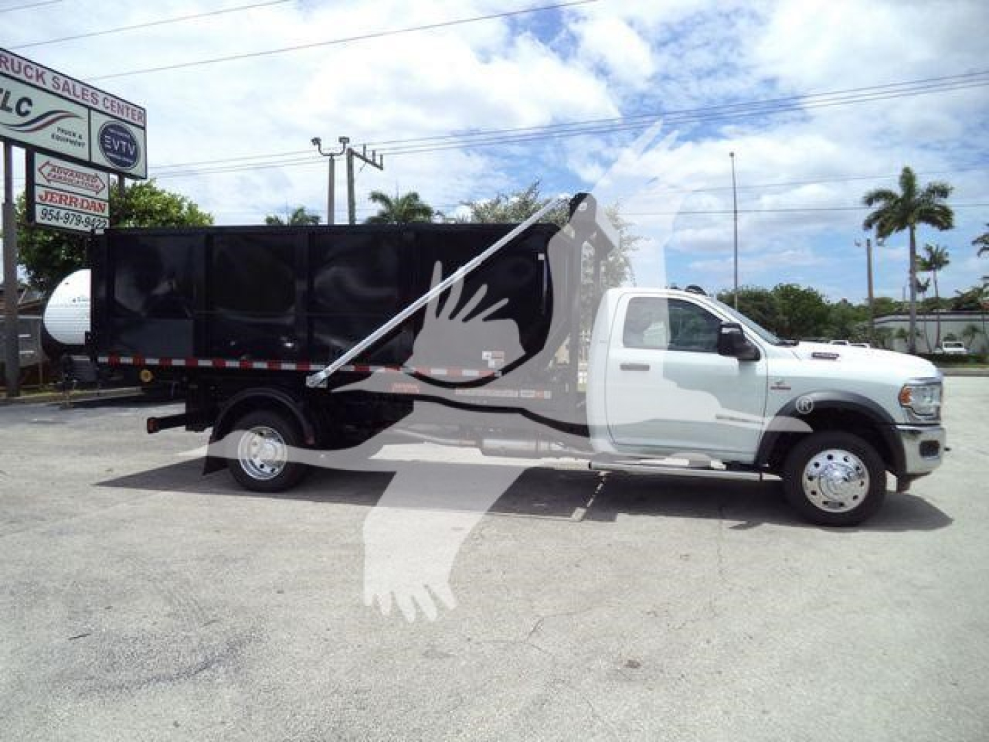 2024 Ram 5500 SLT roll-off truck side view showing black dump bed and white cab.