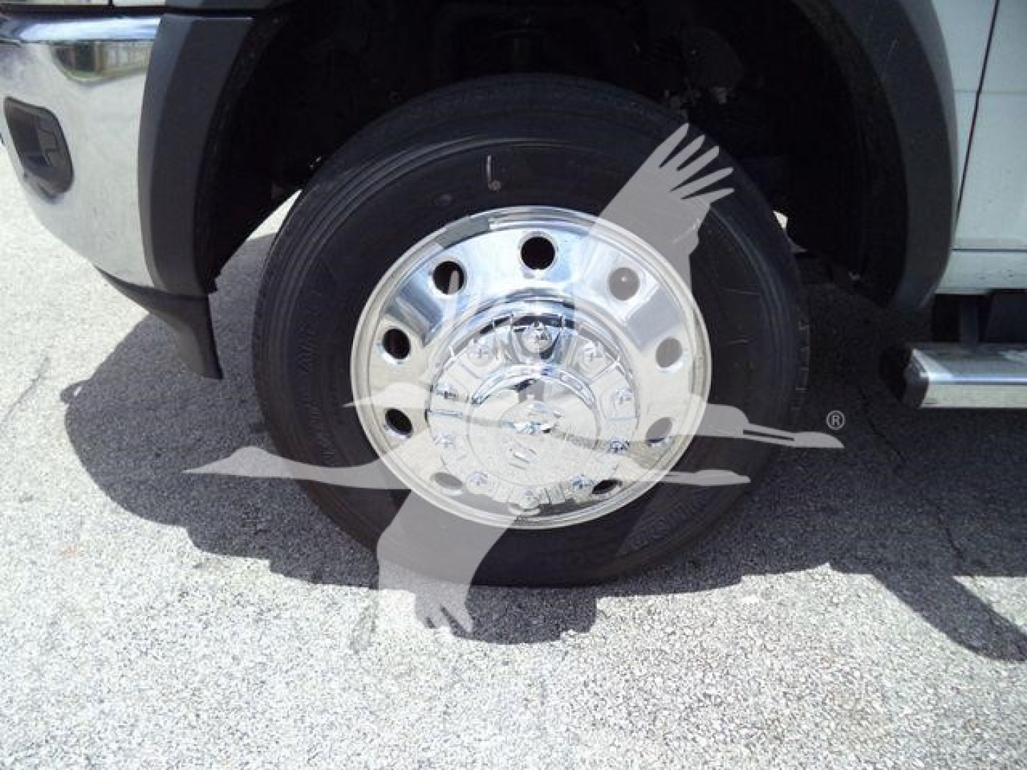 Ram 5500 SLT wheel assembly showing chrome steel hubcap and tire in front left fender well.