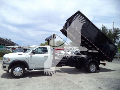 Truck bed tilted dump body on a white 2024 Ram 5500 SLT chassis with hydraulic tipping mechanism.