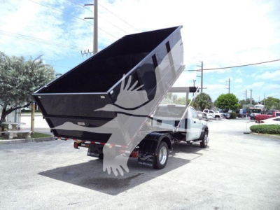 2024 Ram 5500 SLT dump bed in raised position attached to truck, side view showing rugged dump bed and rear wheels.