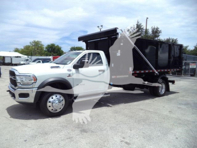 Ram 5500 dump truck in-service profile showing large dump bed with hydraulic mechanism and dual rear wheels, chrome front grille, white cab, and black dump body.