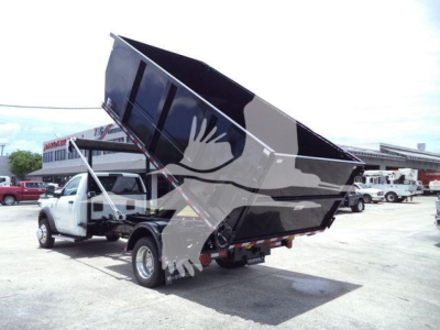 Ram 5500 dump truck raised bed view showing truck with dumping cargo bed and cab in a dealership lot.