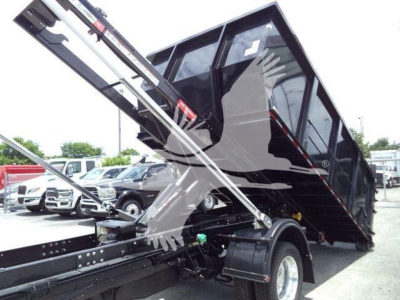Ram 5500 dump truck bed in upraised position showing hydraulic arms and chassis with cargo bed, wheel, and hydraulic components visible.