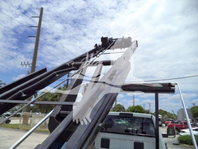 Ram 5500 roll-off truck with hydraulic arm and grapple in front view showing parts and hydraulic components.