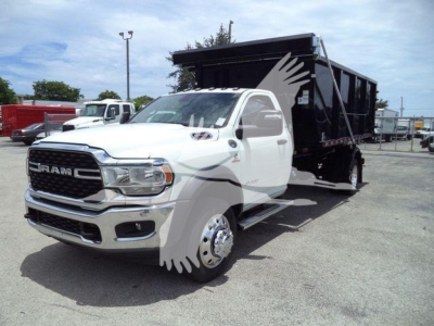 2024 Ram 5500 SLT dump truck in white cab with black dump body, front grille showing RAM letters, side view on lot.