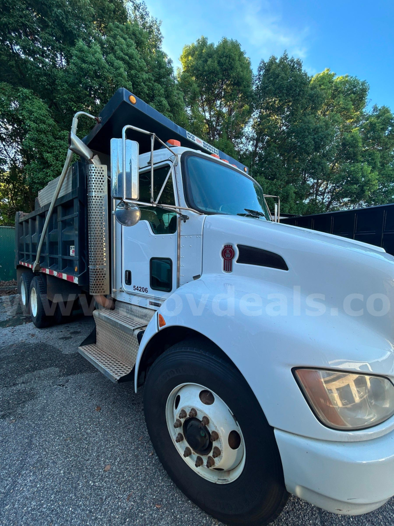 Kenworth T370 dump truck in-service showing front left side with white cab and black dump bed, stock number 176-6671.