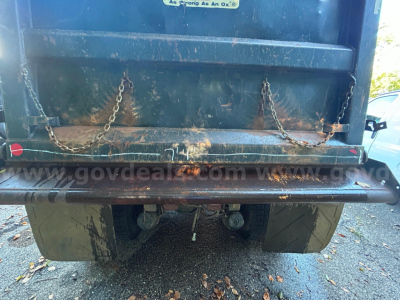 Kenworth dump truck rear showing rear bumper, chains, and tires.