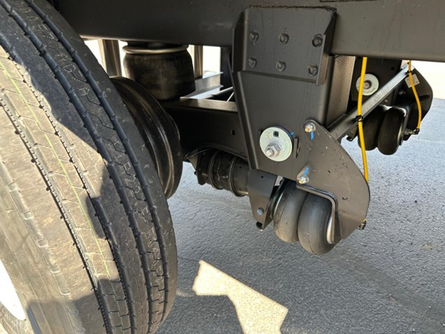 Trailer undercarriage showing leaf spring and caster wheel assembly of a 2026 Timpte Super Hopper trailer.
