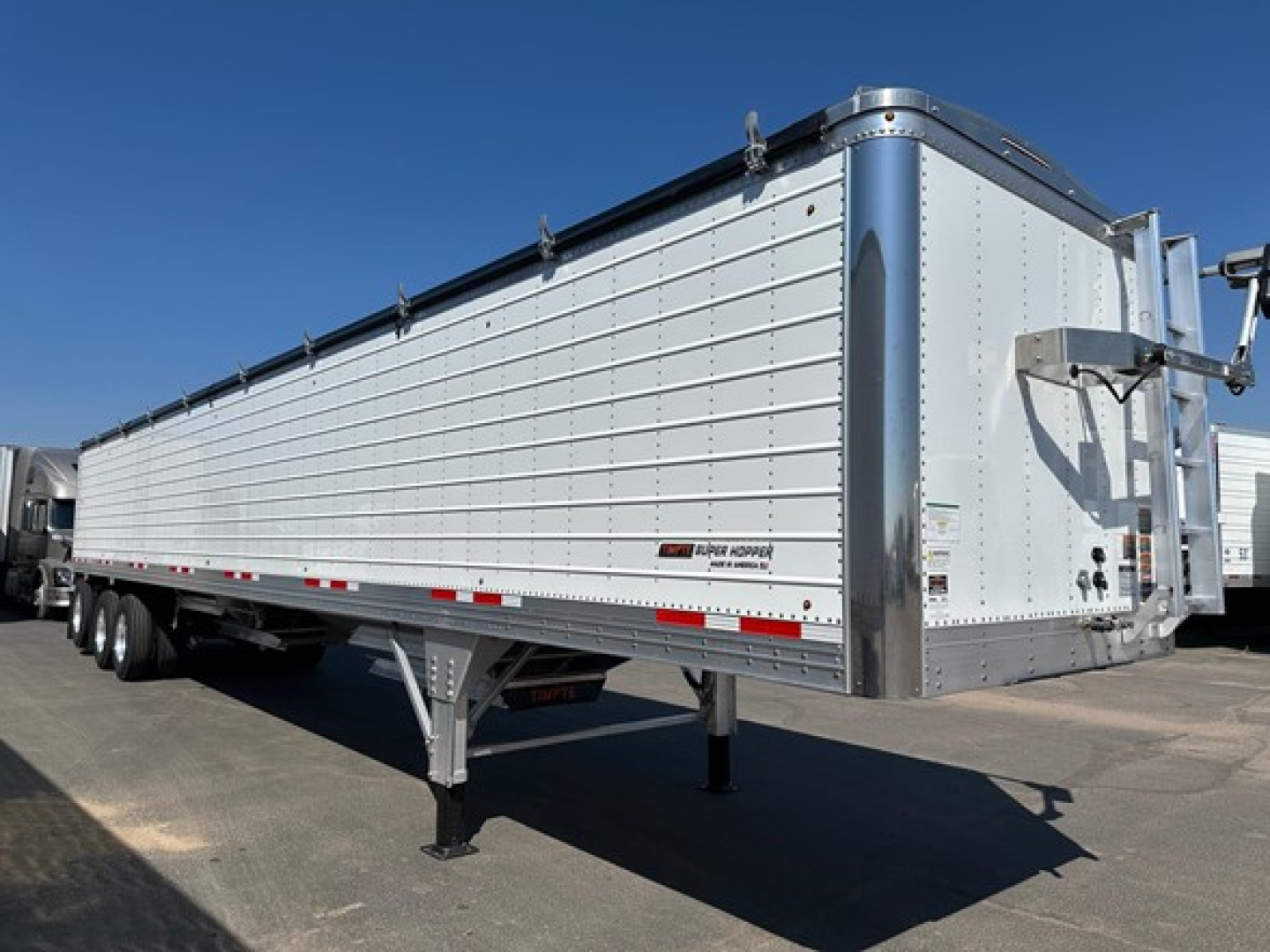 Timpte Super Hopper trailer showing side and front, aluminum panel sides, dual-axle rear, and front landing gear.