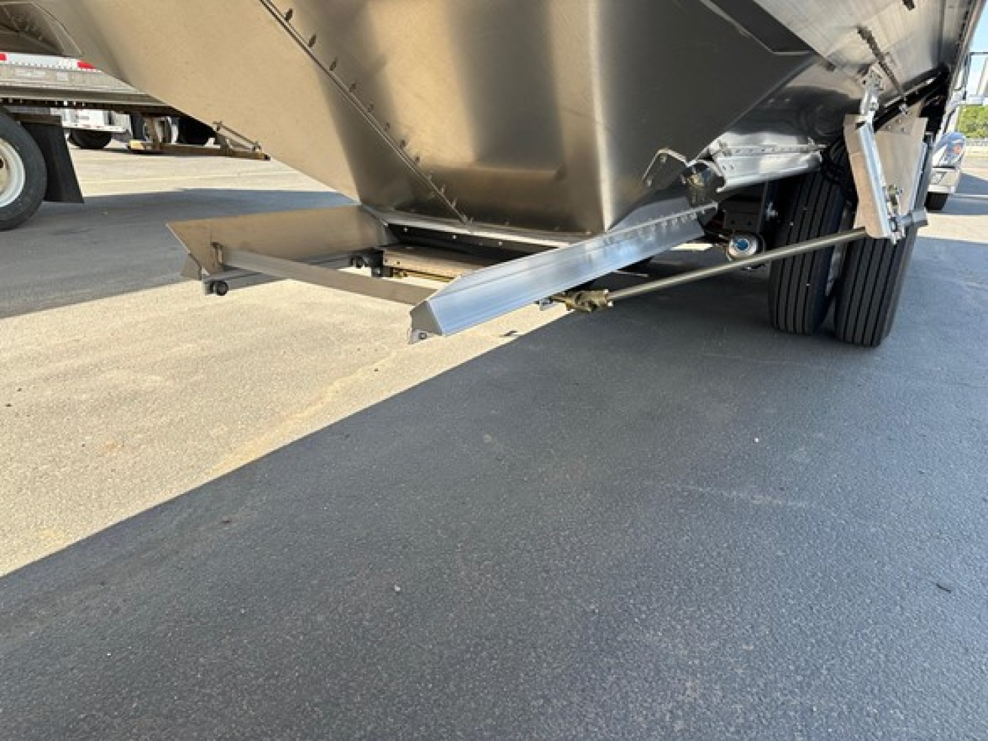 Timpte hopper trailer hitch area showing hitch and support bar under hopper with dual rear wheels visible.