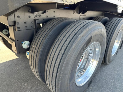 Trailer axles and dual rear tires of a 2026 Timpte Super Hopper trailer showing dual tandem steel wheels and tire treads