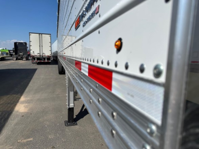 Side view of a 2026 Timpte Super Hopper trailer showing riveted aluminum side with reflectors and leveling legs.