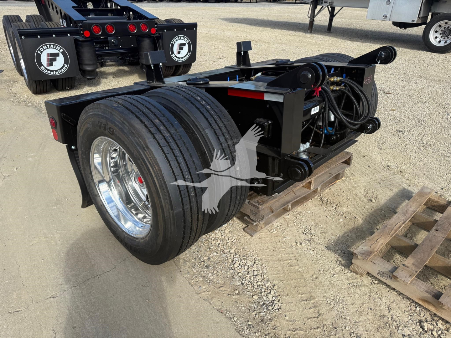 Fontaine flip axle trailer undercarriage with dual rear tires and hydraulic components visible, mounted on a wooden pallet.