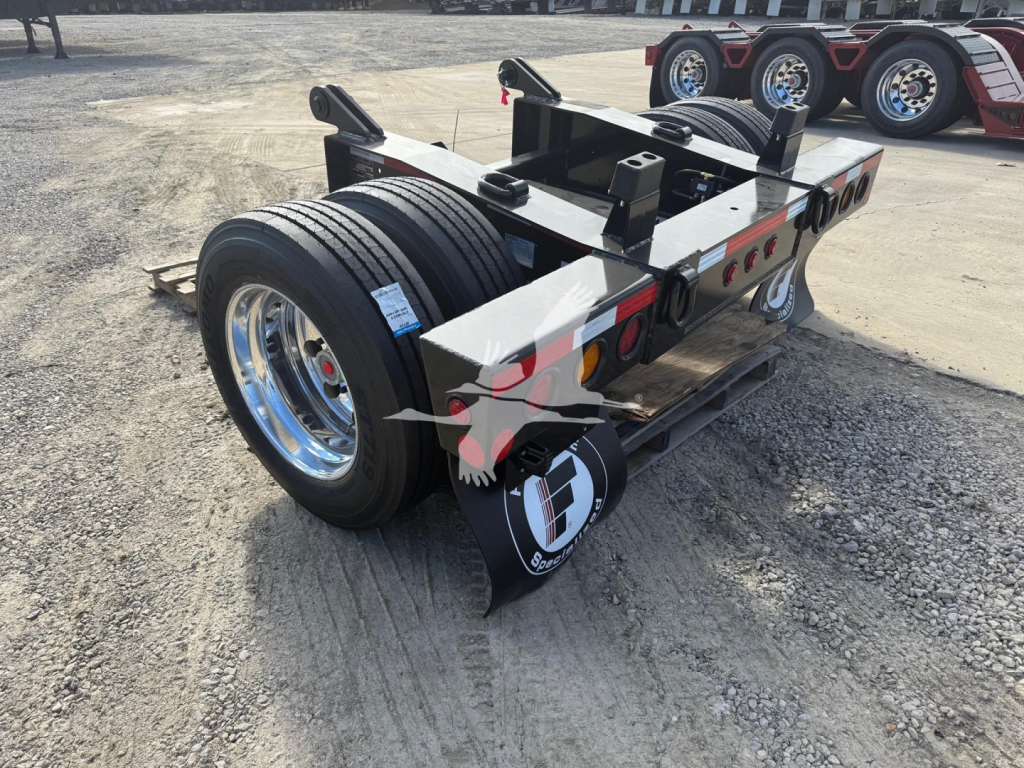 Trailer axle assembly showing twin wheels and flip axle hardware with logoed mudflaps