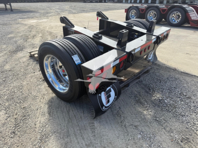 Trailer axle assembly showing twin wheels and flip axle hardware with logoed mudflaps