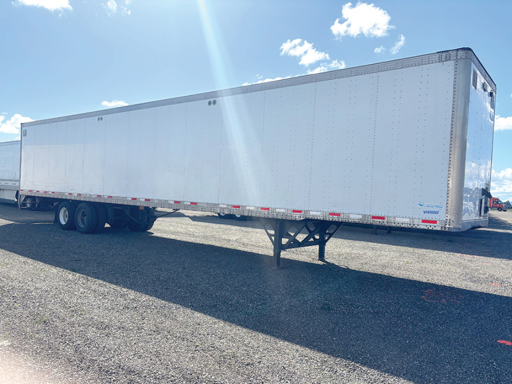 Vanguard aluminum van trailer with long rectangular cargo area, PTO legs down, dual rear wheels visible. No text legible on the trailer surface in this view.