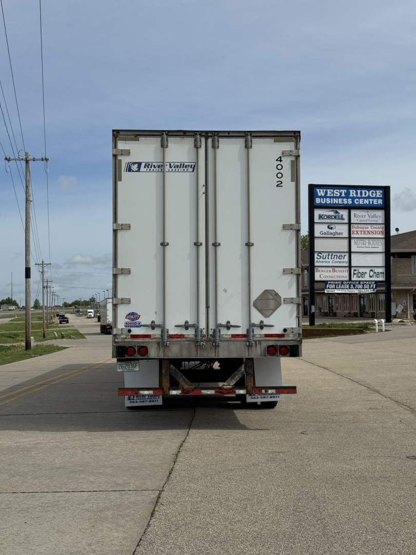 Trailer back view of a 2014 Utility 4000Dx trailer with rear doors, license plate area, and business center signs on right.