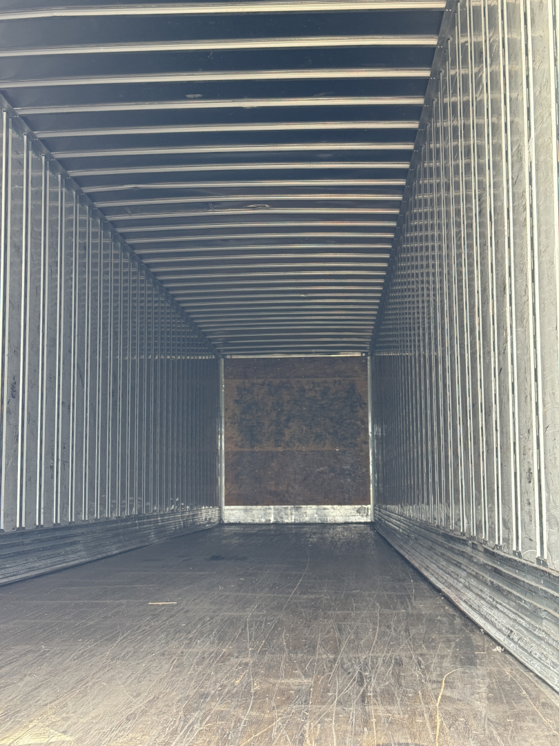 Trailer interior of a 2014 Utility 4000Dx showing metal walls and wooden end panel, empty cargo space.