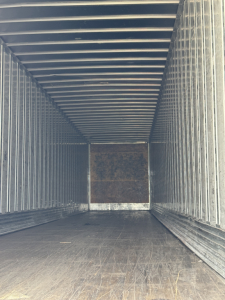 Trailer interior of a 2014 Utility 4000Dx showing metal walls and wooden end panel, empty cargo space.