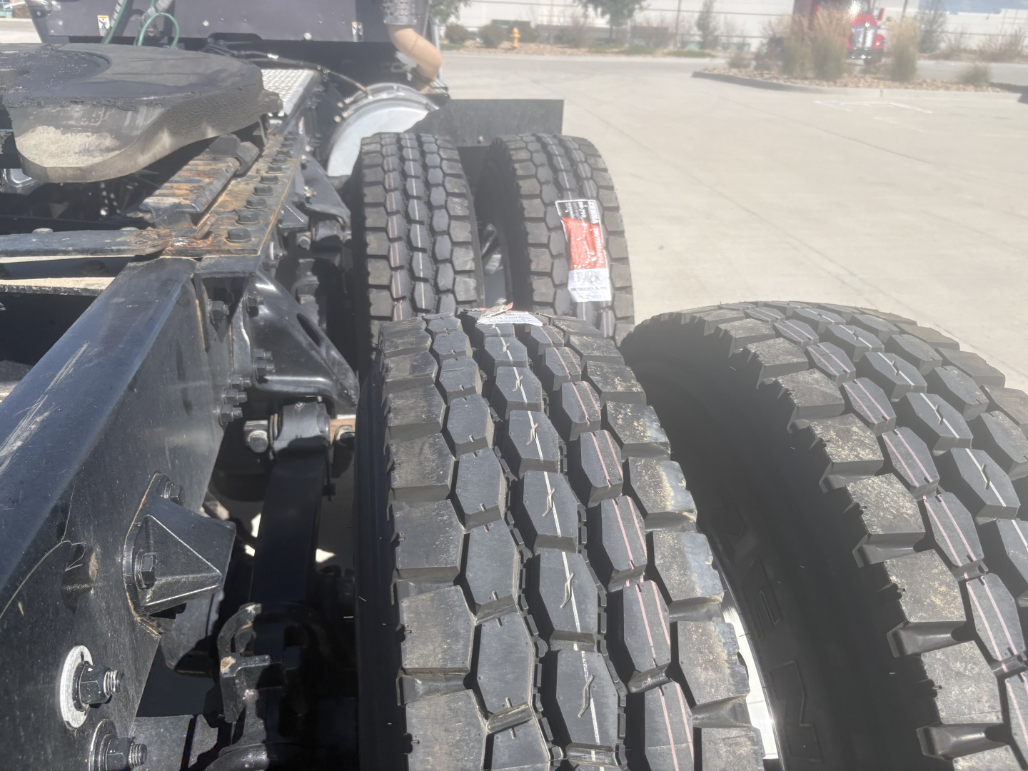Kenworth T680 tractor chassis with dual rear tires and fuel/tank area visible, view of wheel treads and frame along left side.