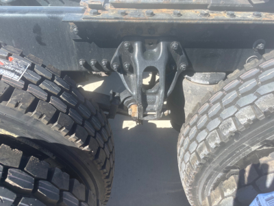 Kenworth T680 front axle area showing dual rear wheels and heavy-duty suspension components