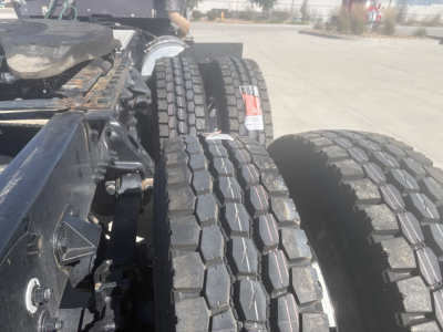 Kenworth T680 tractor chassis with dual rear tires and fuel/tank area visible, view of wheel treads and frame along left side.