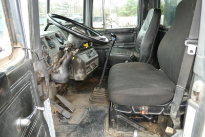Mack RD688S cab interior showing steering wheel and driver seat with manual gearshift and dashboard.
