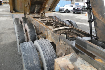 Mack RD688S chassis showing dual rear axle and weathered frame with rust speckling and tire set in yard.