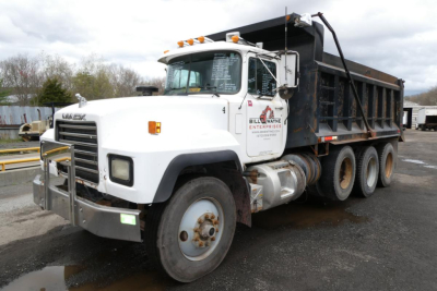 Dump truck with white cab and black dump bed showing MackRD688S in-service vehicle and Bill Wayne Enterprises logo on door; front grille and bumper; DOT lights; VIN visible on listing text
