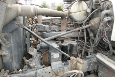 Mack RD688S engine bay showing diesel engine components and surrounding hoses and wiring.