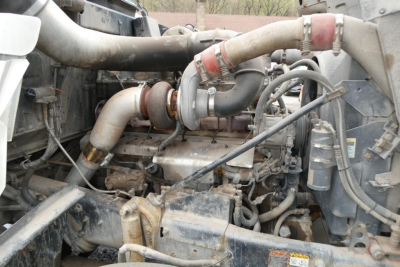 Mack RD688S engine bay showing intake piping, turbocharger, hoses, and surrounding components.