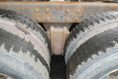 View of a Mack RD688S rear undercarriage showing tandem wheel setup and driveshaft yoke between dual tires.