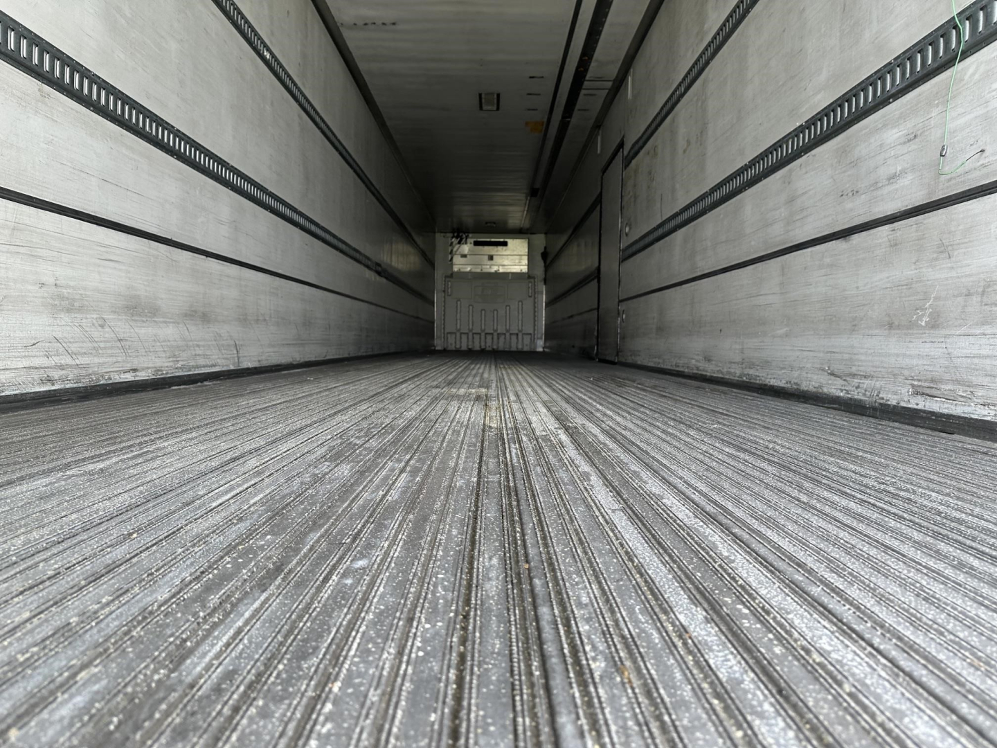 Trailer interior showing ribbed metal floor and side walls with rails, empty cargo area in a 2015 Utility 3000R reefer trailer.