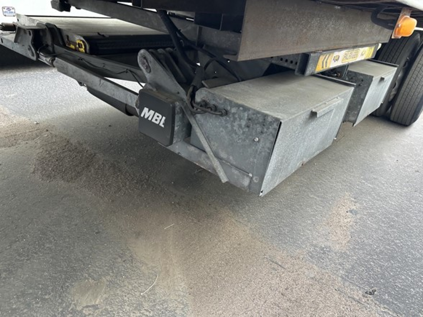 Trailer undercarriage showing MBL tail hitch and metal toolbox, rear wheels, and undercarriage frame